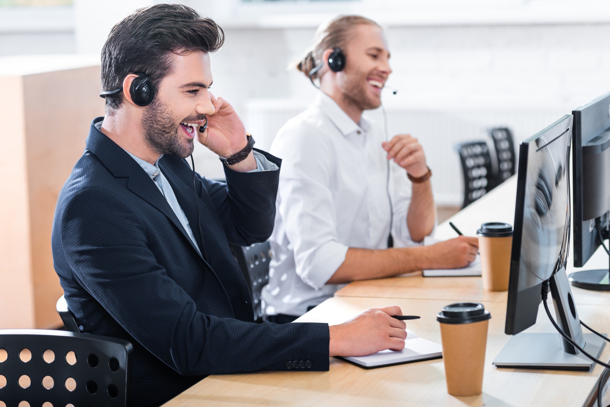 side-view-of-male-call-center-operators-in-headsets-at-workplace-in-office.jpg